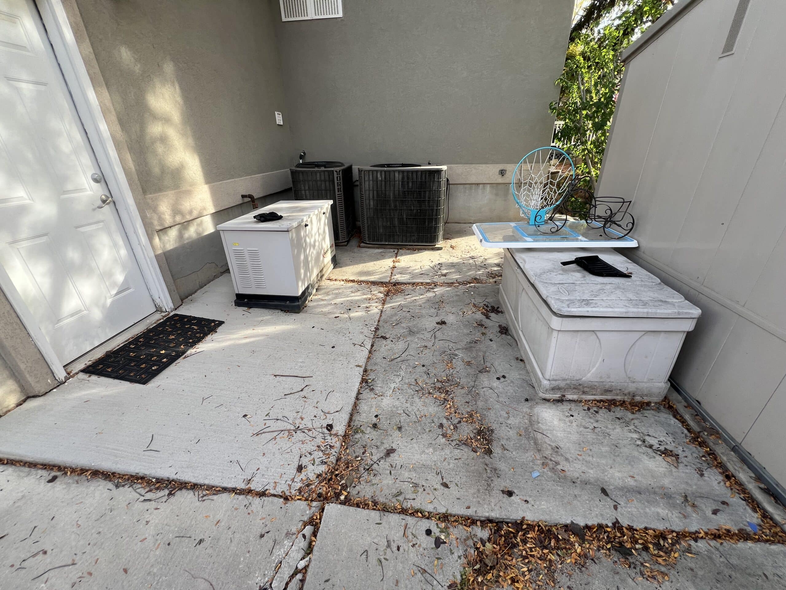 Settled utility pads behind a South Jordan garage, dropped roughly three inches below grade